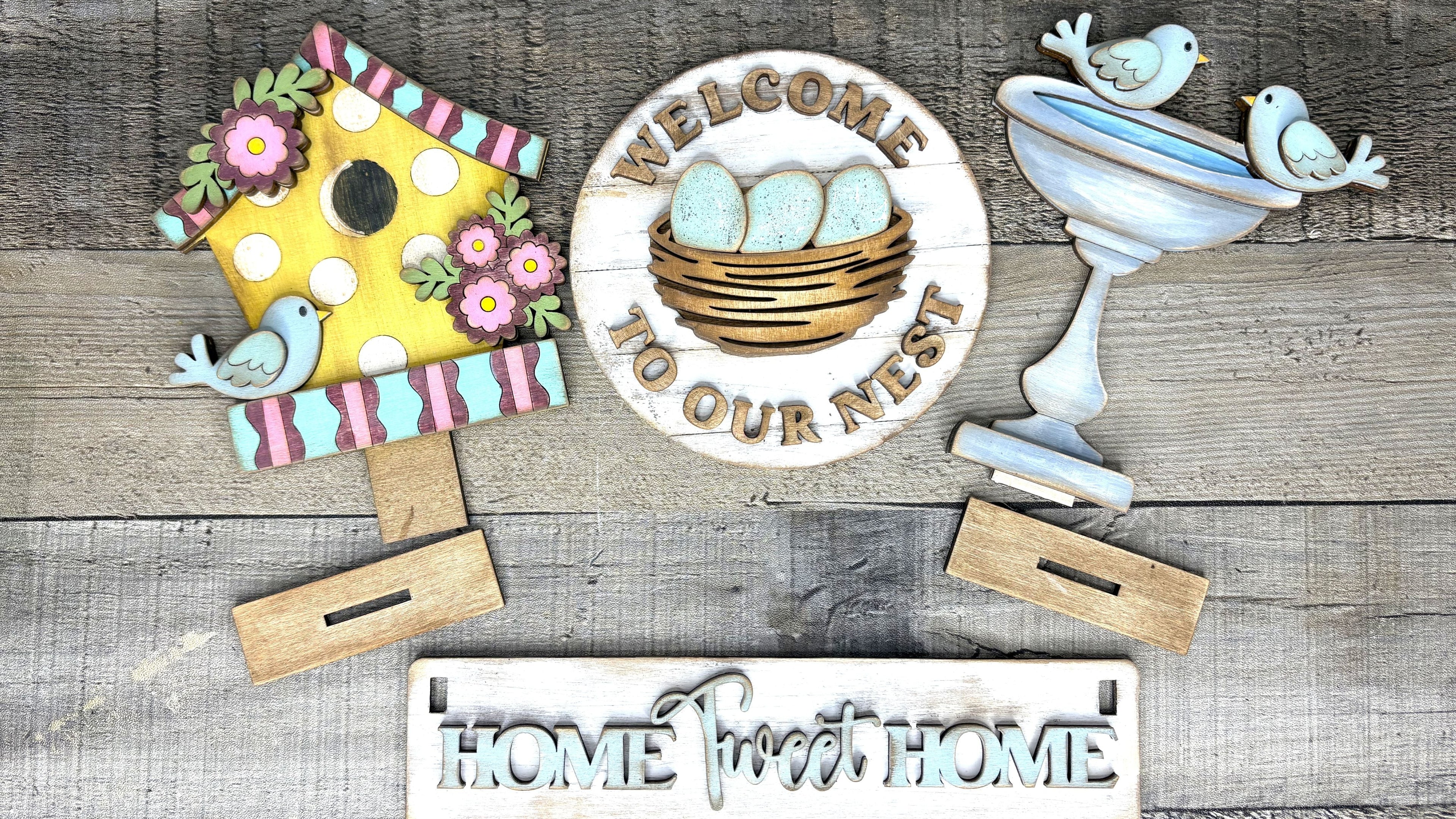 Interchangeable Welcome to Our Nest DIY wood craft kit with birdhouse, birdbath, and nest sign

Laser-cut spring farmhouse DIY wood décor kit with interchangeable seasonal pieces

Painted Welcome to Our Nest craft kit displayed with birdhouse and birdbath décor

DIY spring wood sign kit with interchangeable base and layered details

Handmade interchangeable farmhouse décor DIY kit by Free Time Treasures