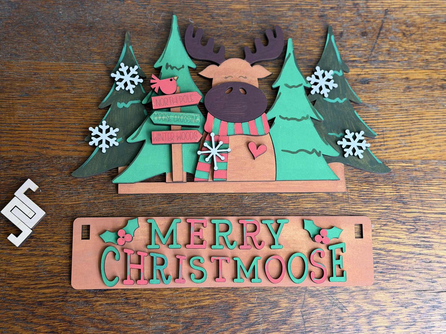 Merry Christmoose DIY Craft Kit featuring laser-cut moose scene, Christmas trees, snowflakes, and festive sign.