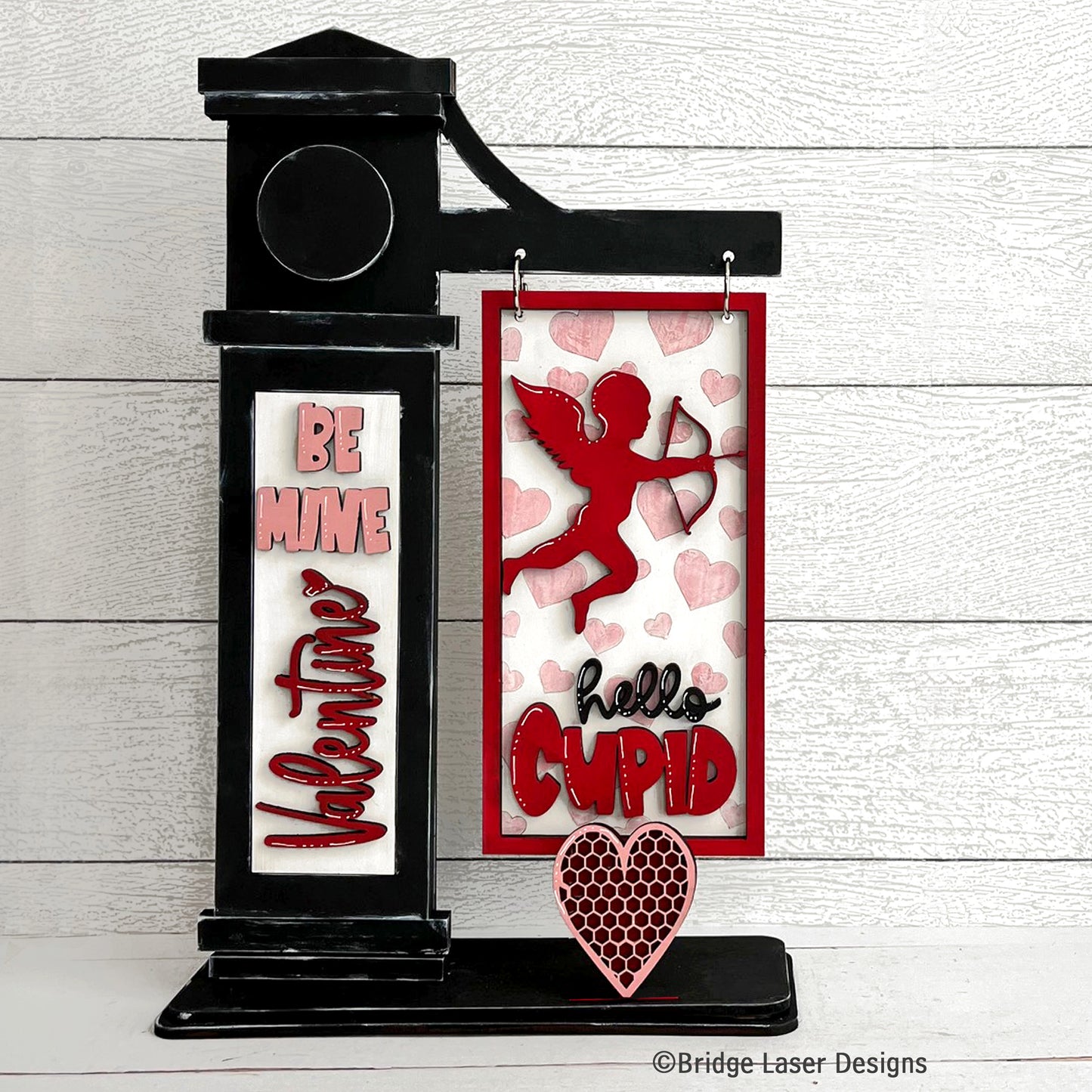 Decorative sign with 'Be Mine Valentine' and 'Hello Cupid' text
