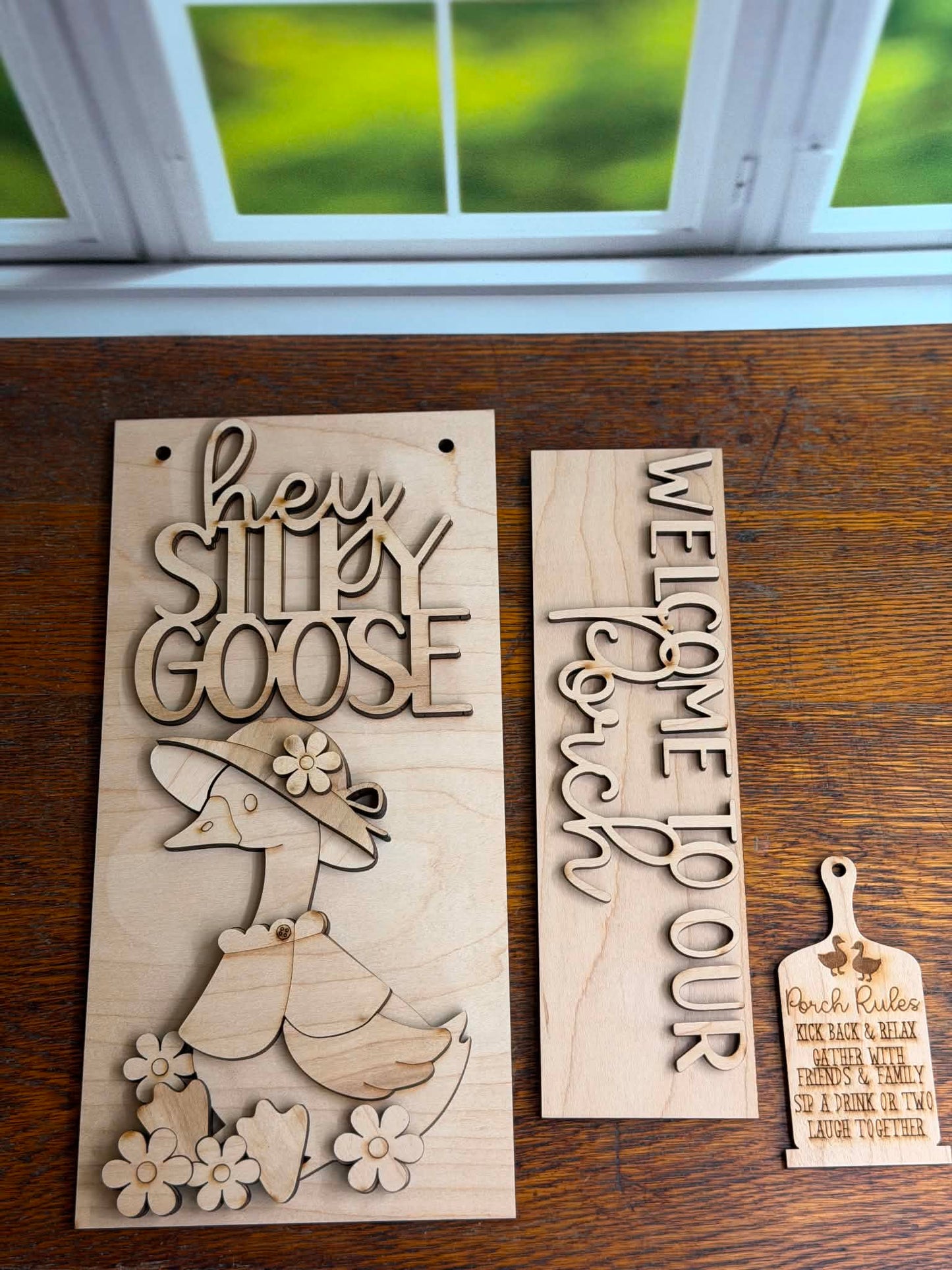 Two wooden signs with engraved text and a duck design on a wooden surface.