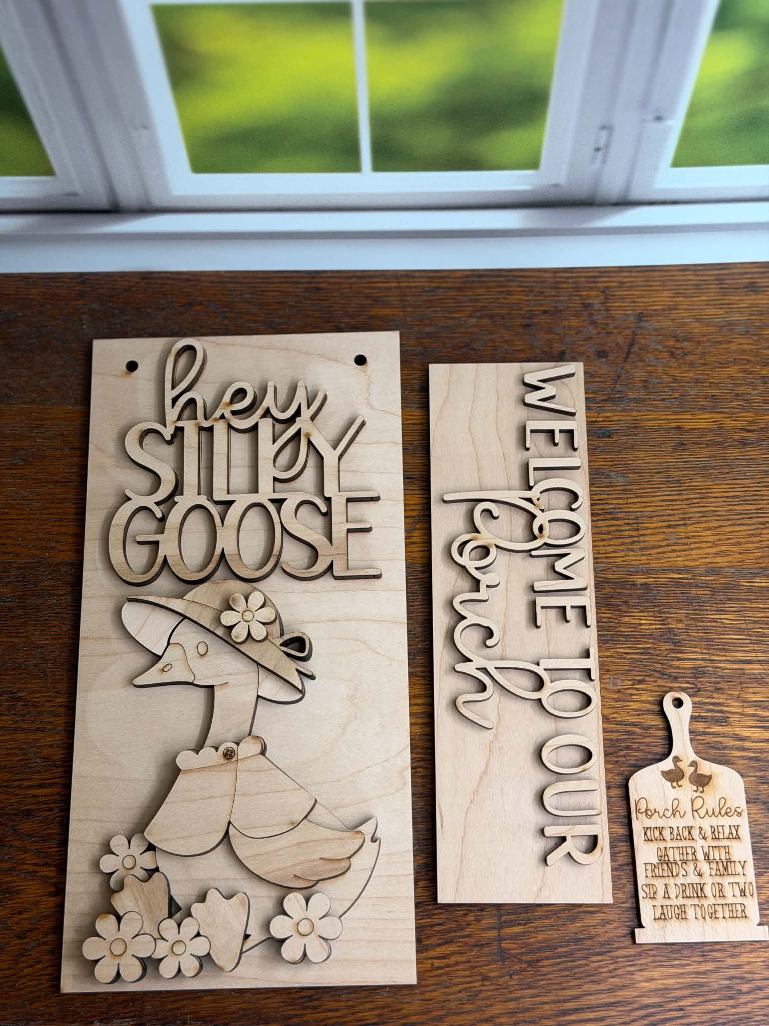 Two wooden signs with engraved text and a duck design on a wooden surface.