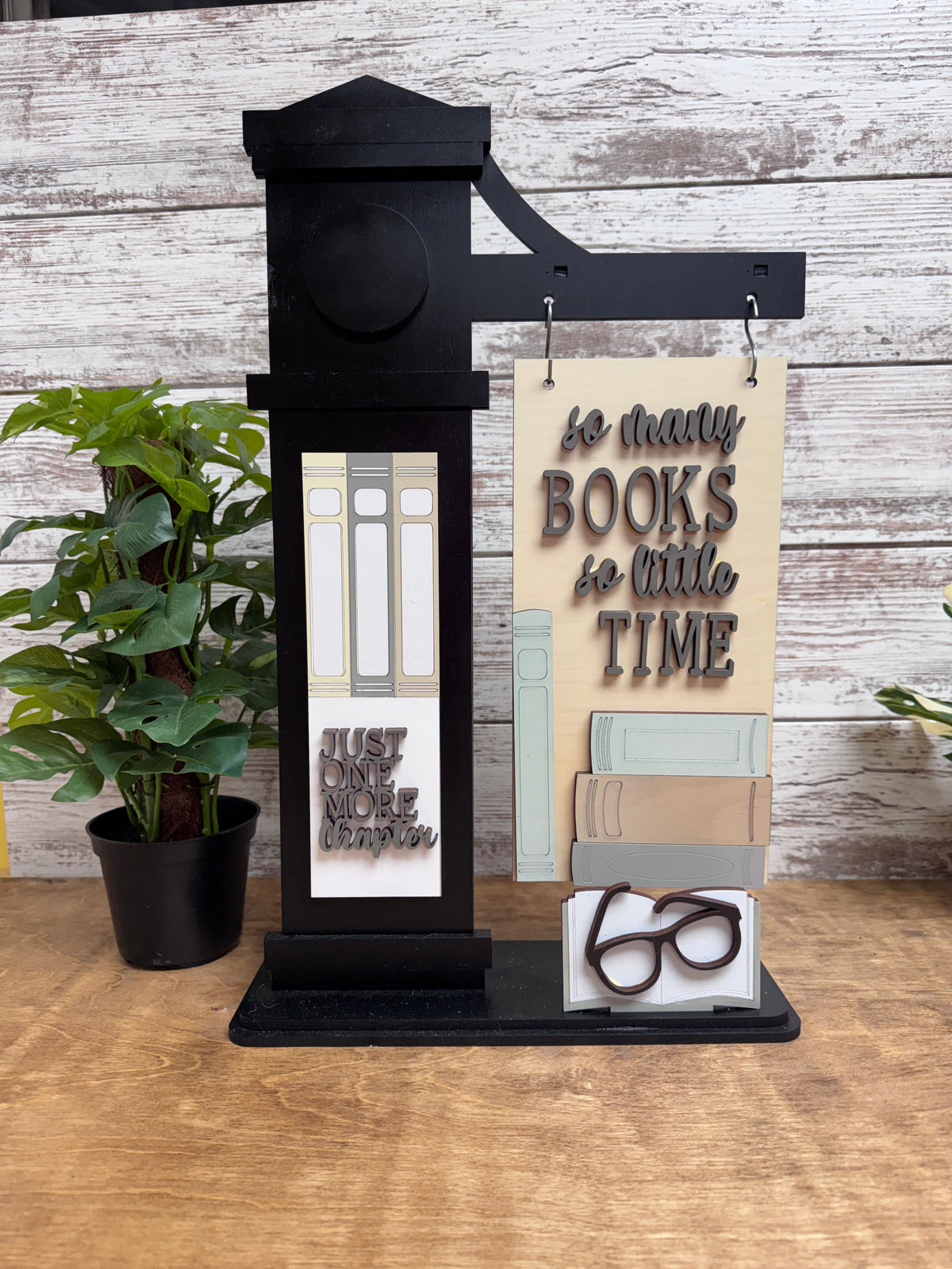 Finished bookworm-themed hanging sign, vertical insert and pop-out accent displayed on a black interchangeable post.
