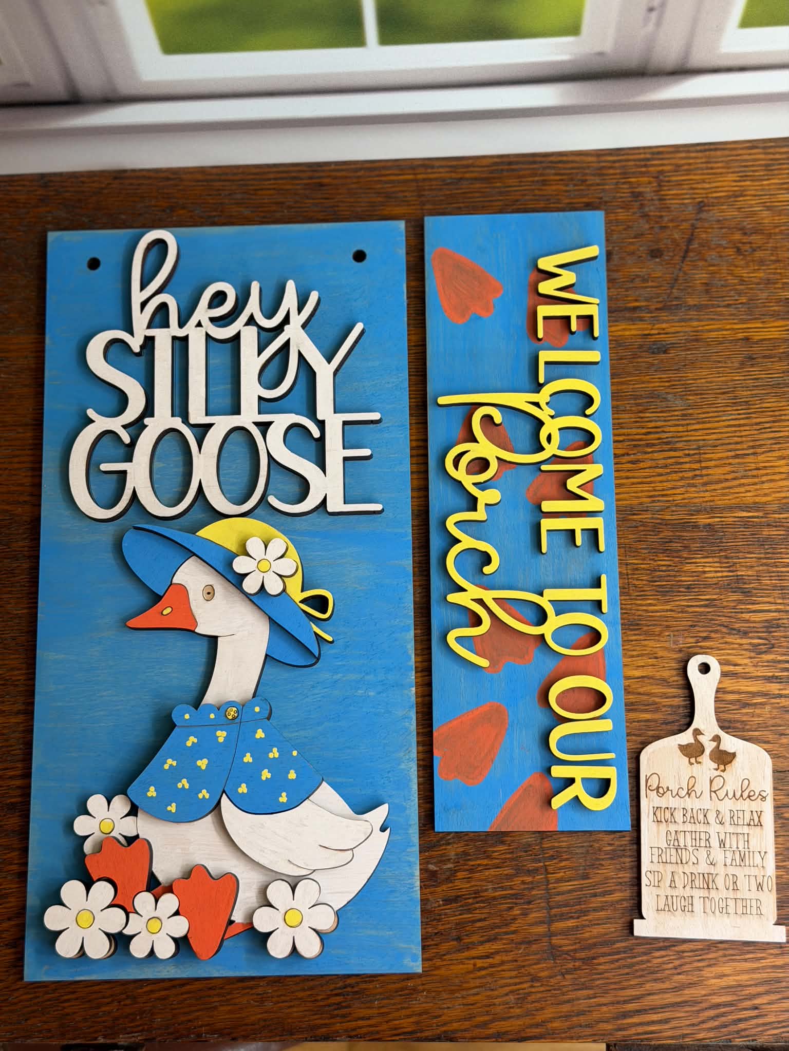 DIY goose porch post craft kit featuring a layered goose wearing a blue hat and jacket, Welcome to Our Porch insert sign, and Porch Rules hanging sign for interchangeable porch post decor.