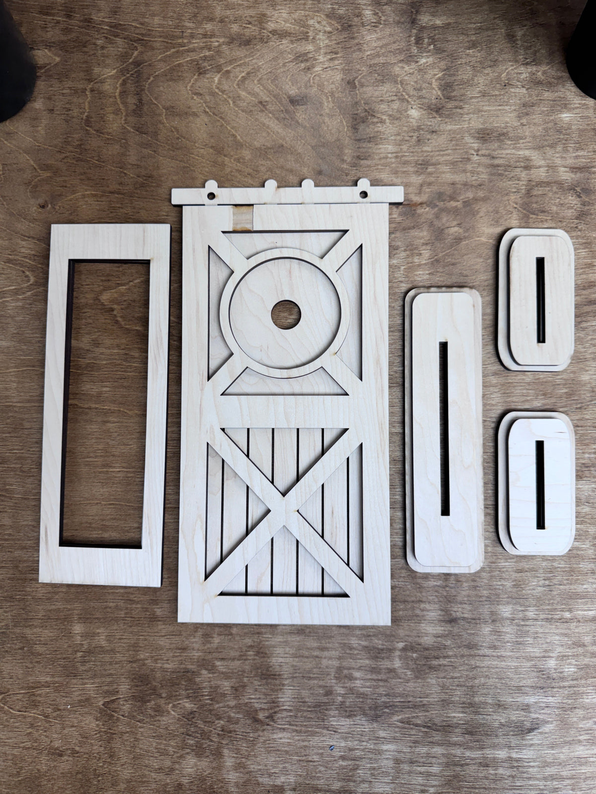 Unfinished laser-cut wood pieces included with the interchangeable post door retrofit kit