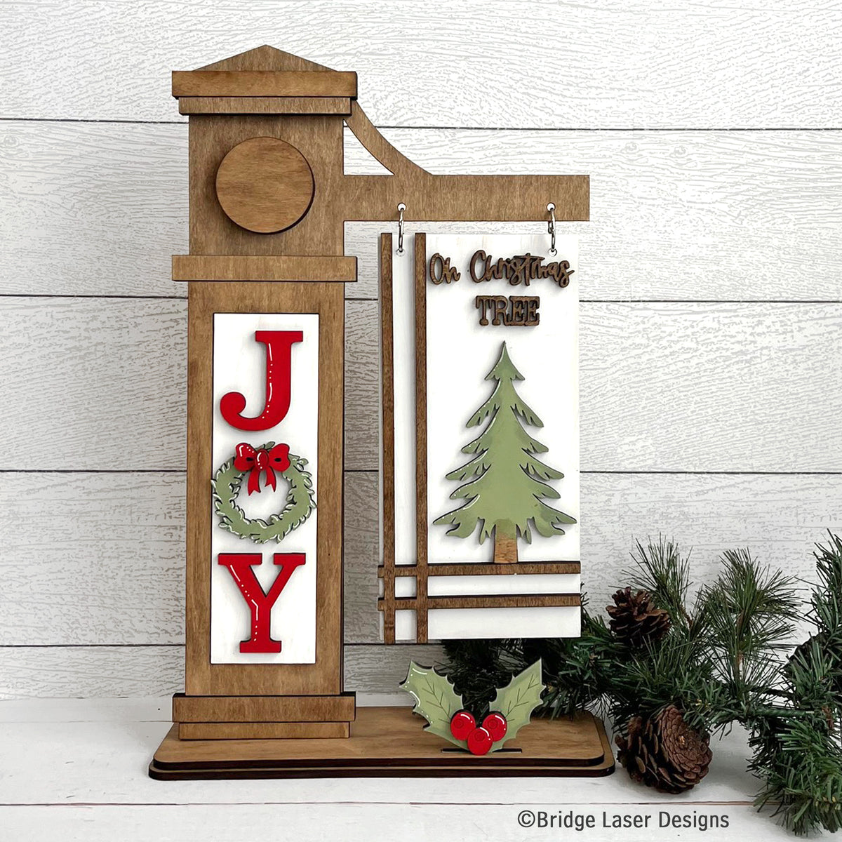 Finished JOY Christmas decoration on a stained wooden post with red JOY wreath insert, green Christmas tree hanging sign and holly berry accent.
 Copy both