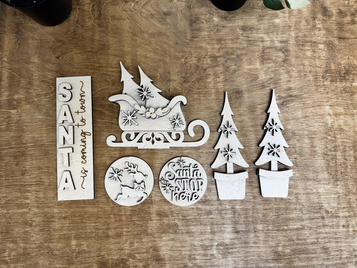 Laser-cut Santa Christmas DIY décor insert with layered sleigh, holiday signs, snowflakes and potted evergreen trees