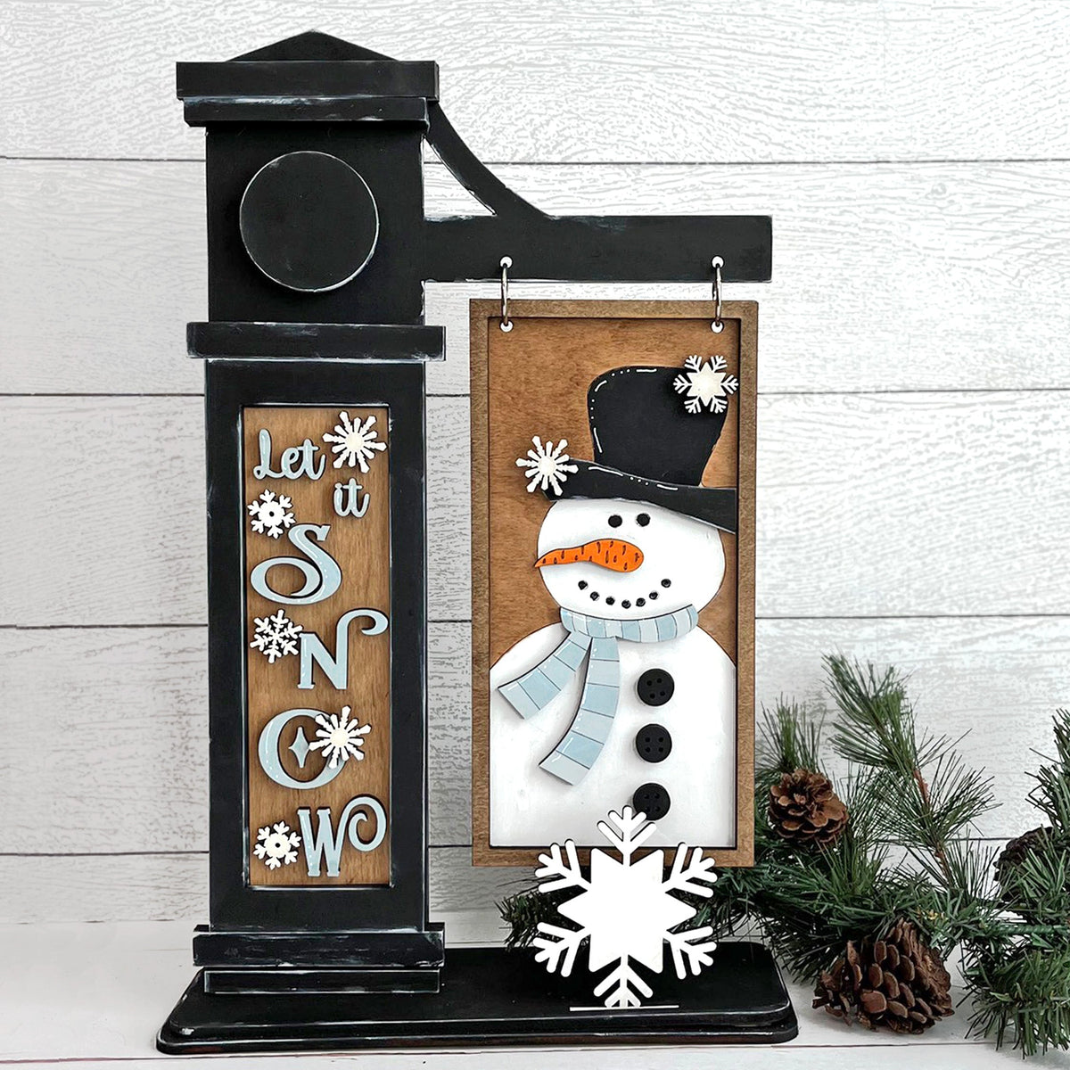 Let It Snow DIY winter craft kit featuring a snowman hanging sign, snowflake pop-out, and interchangeable post insert.