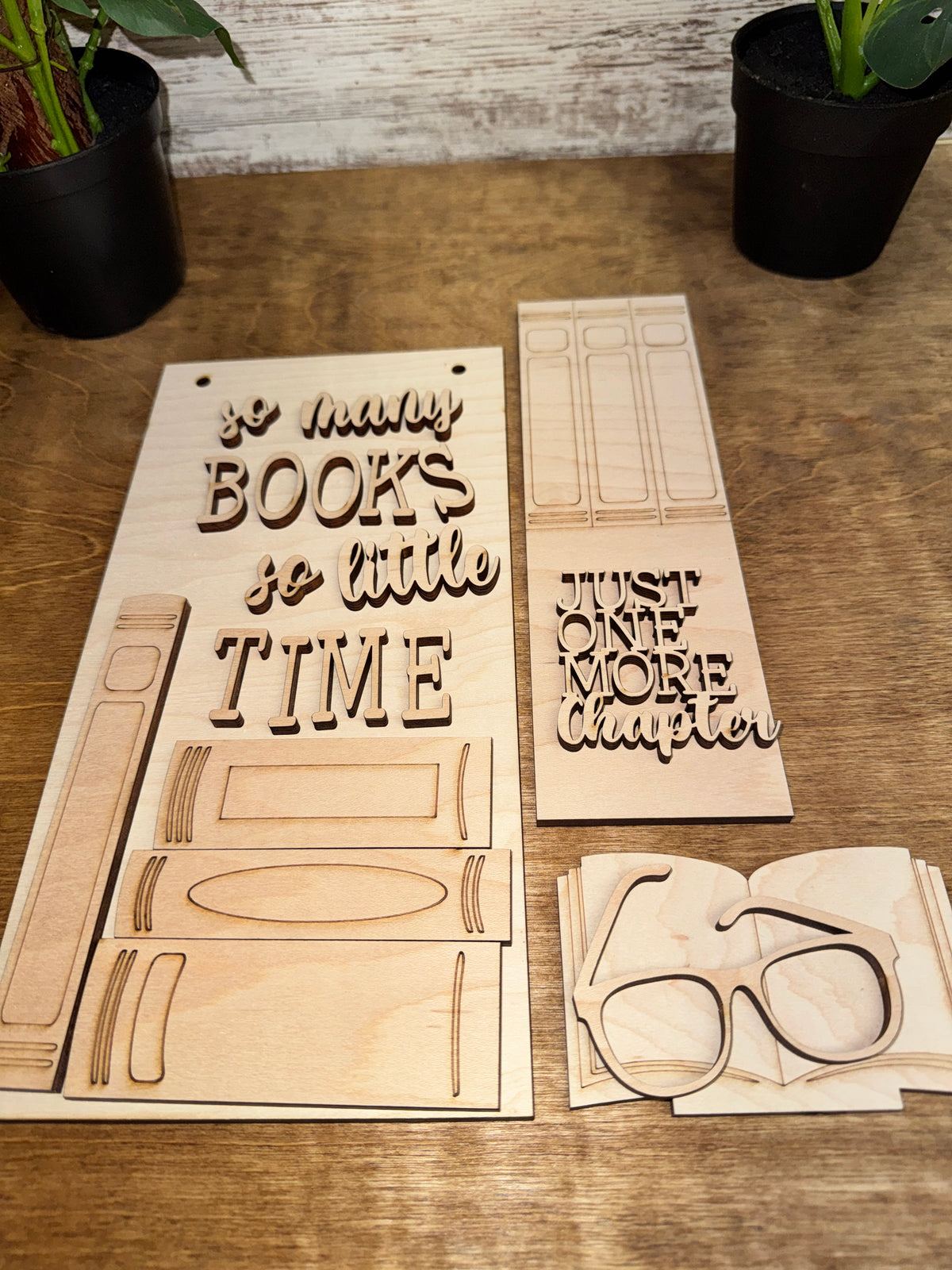 Unfinished laser-cut wooden book lover craft kit with coordinating hanging sign, vertical insert and book-themed accent.