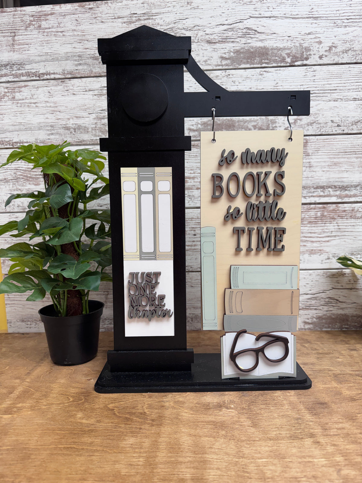 Finished So Many Books So Little Time wooden sign and reading-themed inserts displayed on a black interchangeable post.